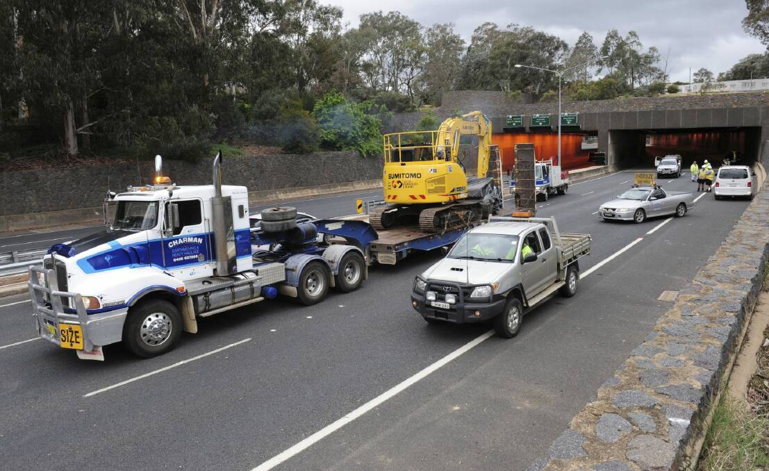 The low loader and excavator are driven out of the Acton tunnel
on Parkes Way on Thursday afternoon. Photo: Graham Tidy