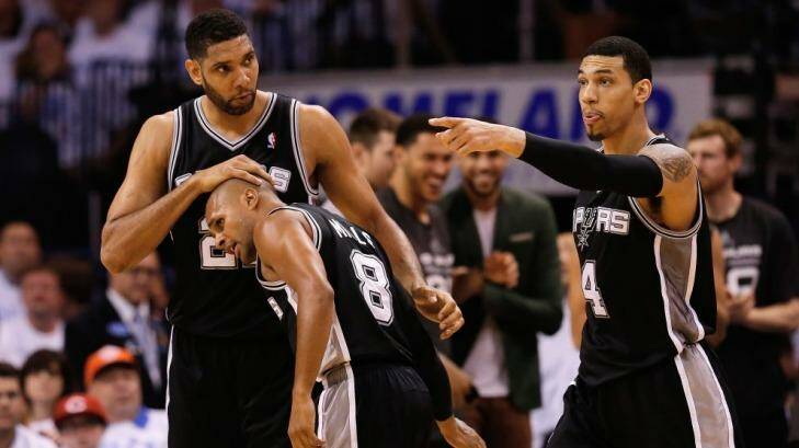 Tim Duncan gives Patrick Mills a congratulatory pat on the head on Sunday. Photo: AFP