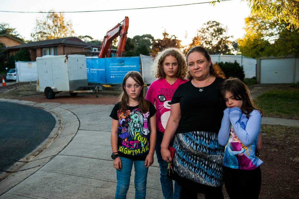 Eden O'Mara with  daughters Kimberley, 10, Jennifer, 12, and Rachael, 7, outside their Mr Fluffy house in Kambah that was demolished on Thursday. She is devastated by the discovery of a cabinet she believes is hers in a shipping container. Photo: Elesa Kurtz