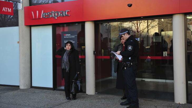 A police officer talking to a member of the public outside the Westpac in the city. Photo: Colleen Petch