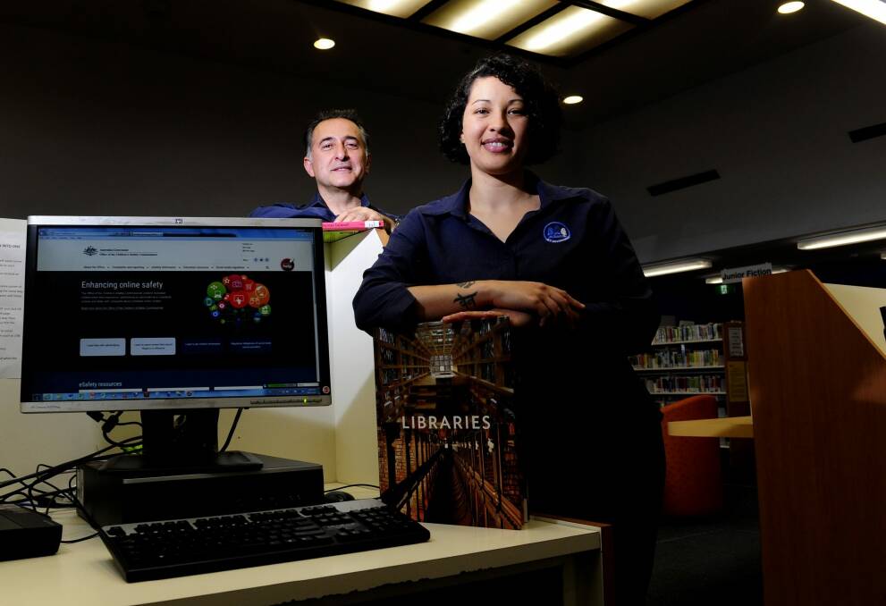 Librarians Dimitris Lioulios and Amanda Diedricks, at the Dickson Library, have both been trained to use the new program eSafe that makes it easier for young people to report cyber bullying. Photo: Melissa Adams