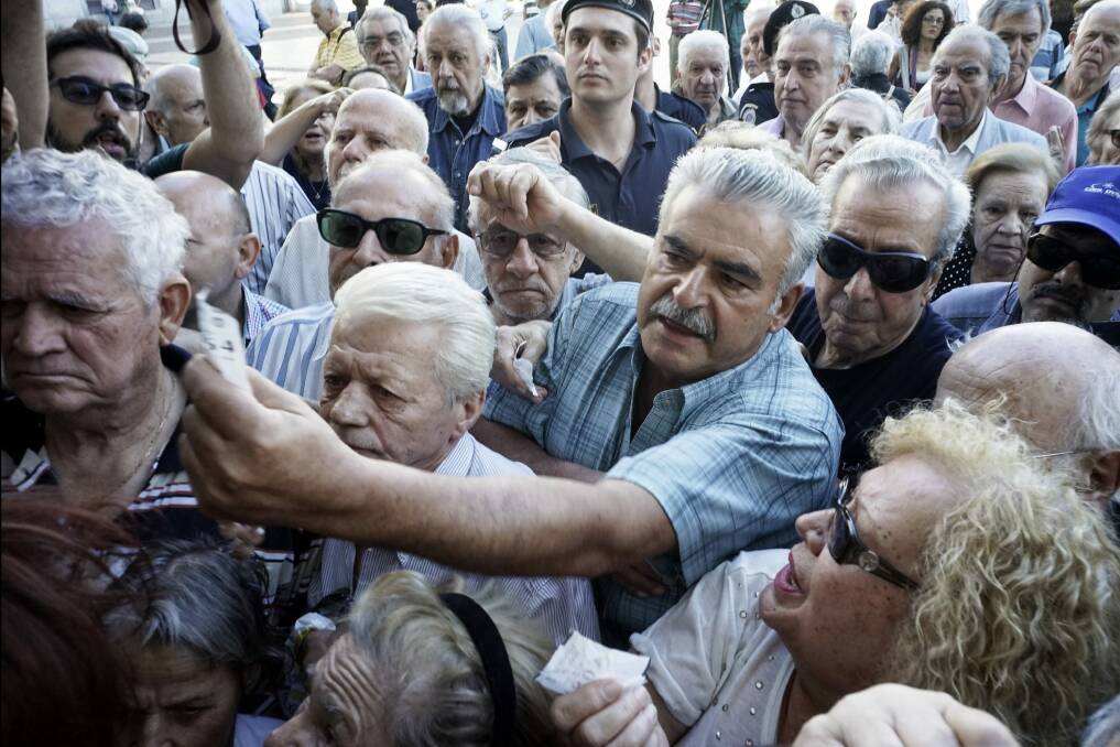 Pensioners queue outside an Athens bank after branches around Greece opened on Wednesday to only allow pensioners to receive a small part of their benefits.  Photo: Milos Bicanski