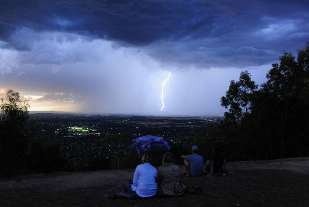People gather at the top of Mt Ainslie as a lightning storm can be seen across Canberra in December. Photo: Melissa Adams