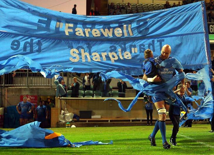 The end ... Nathan Sharpe runs through a banner with his children ahead of his last game in Perth. Photo: Getty Images