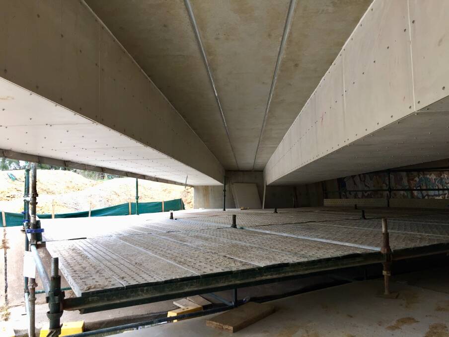Scaffolding installed under a bridge on Flemington Road, where two sets of cable trunking – enclosures used to protect electrical cables – have been installed. Photo: Blake Foden