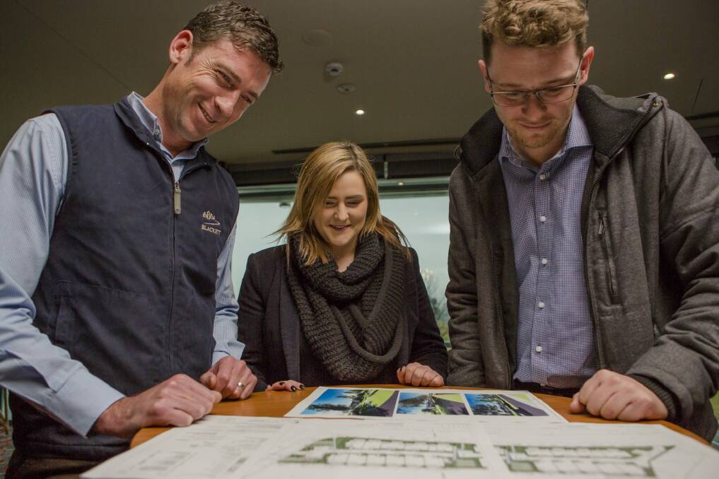 Blackett Property Group owner Geoff Howarth, project manager Sophie Duncan and contracts manager Edgar Sharp go over plans for the Chisholm development. Photo: Jamila Toderas
