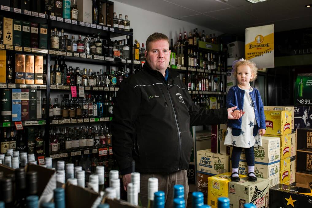 Owner of Urban Cellars Curtin, Paul Cains - with his four-year-old daughter Sophie - fears the stalemate between the owners and residents could kill the local shops. Photo: Jamila Toderas