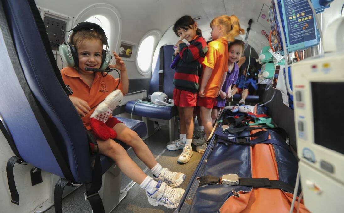 The Royal Flying Doctor Service simulator aircraft touched down at the Canberra Girls Grammar Junior School in Deakin. Prep students got the chance to explore the cockpit and the patient treatment area. Five-year-old Lucia Capezio, left, tries on some headphones.
 Photo: Graham Tidy