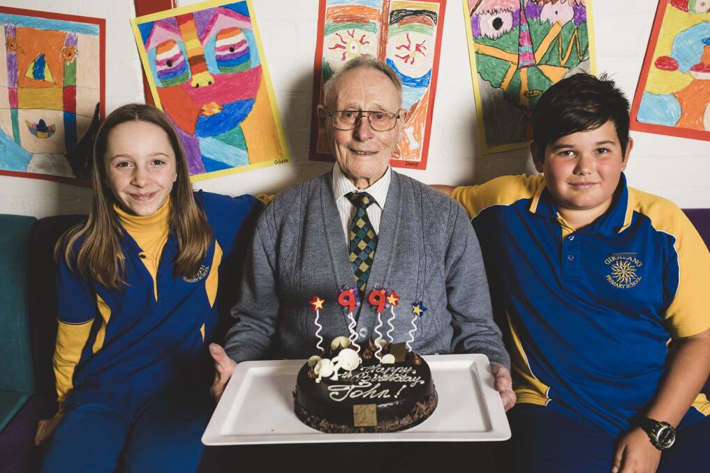 Rat of Tobruk John Fleming celebrates his 99th birthday on Friday with Giralang Primary School captains Selima Macadam and Shae Pressley, both 11. Photo: Jamila Toderas
