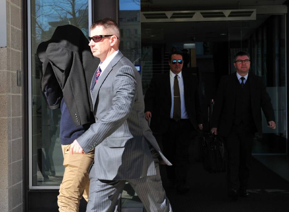On a $10,000 surety: ADFA cadet Harlan Agresti is escorted from the ACT Magistrates Court. Photo: Karleen Minney