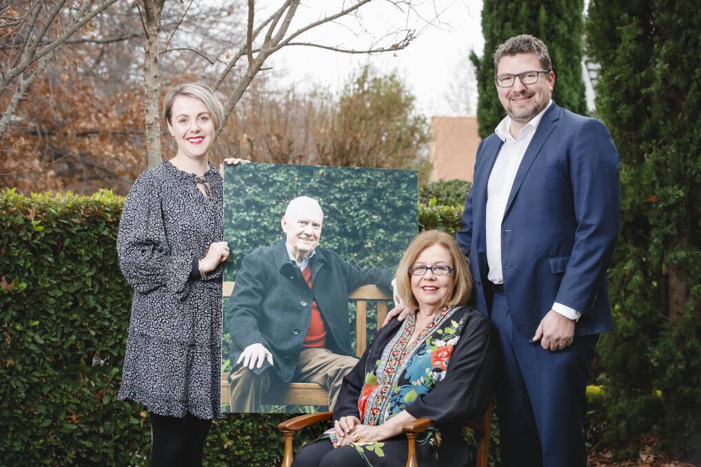 Steve Doszpot's daughter Amy, his widow Maureen and son Adam, with a photo of the late MLA, who has been posthumously awarded a Medal of the Order of Australia. Photo: Sitthixay Ditthavong