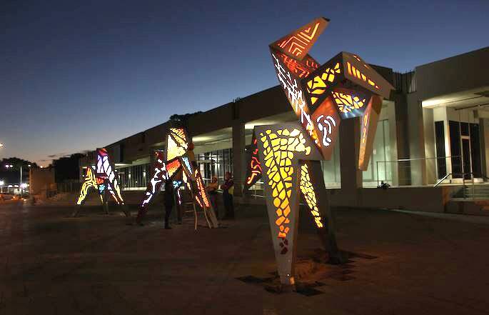 The Origami Horses lit up at night.