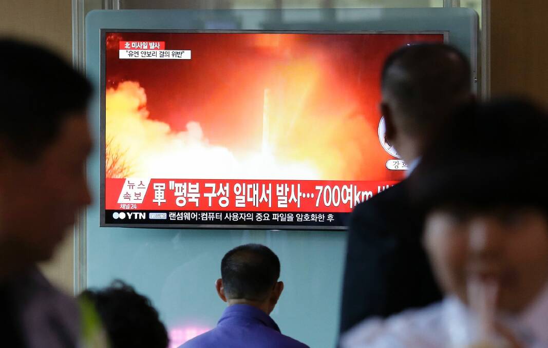 South Korean commuters at Seoul Railway Station watch footage of this week's missile launch. Photo: Ahn Young-joon