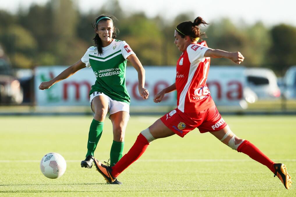 Canberra United defender Rebecca Kiting passes the ball past Rosie Sutton of Adelaide. Photo: Morne de Klerk