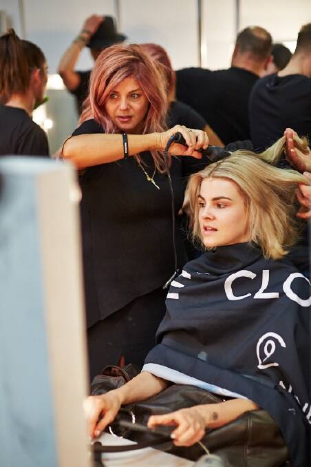 Celebrity hair stylist Renya Xydis working on model Ruby Jean Wilson's hair at Fashion Week.