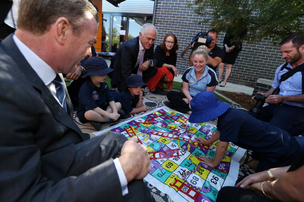 "Who's winning?": children at the centre play Snakes and Ladders. Photo: Andrew Meares