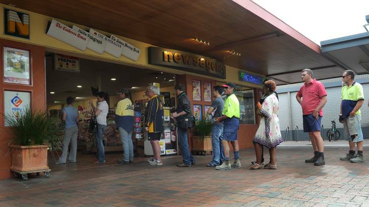 People line up at the Dickson news agency  to buy tickets for tonight's Oz Lotto, which has jackpotted to $100 million. Photo: Graham Tidy
