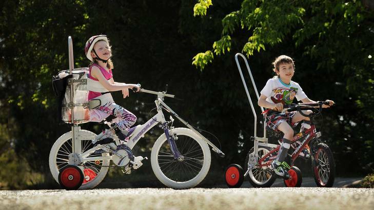 8-year-old Isabella Stokes  and her neighbour, Jack Williams, both suffer from cerebral palsy and have had bikes modified so they can  ride. Photo: Colleen Petch