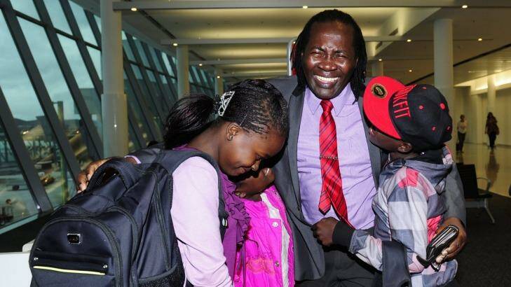 Felix Machiridza with his children from left, Christabel Tapiwa,14, Clarice Tanaka, 8, and  Clarence Takunda,13, arrived at Canberra International Airport after not seeing each other for four years. Photo: Melissa Adams