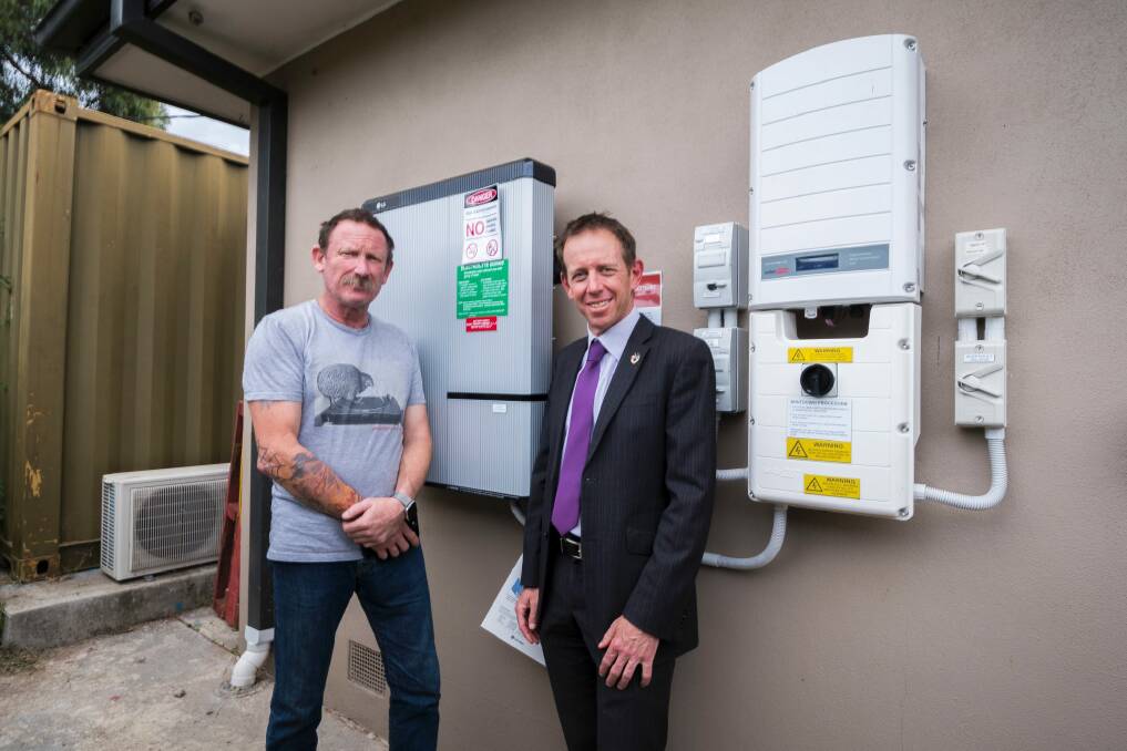 Alex Humphrys and Shane Rattenbury standing in front of the battery storage system. Photo: Dion Georgopoulos
