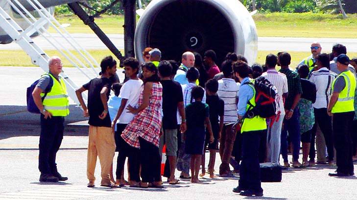 Tamil asylum seekers board an aeroplane on Cocos Island bound for the Australian mainland. Photo: AAP
