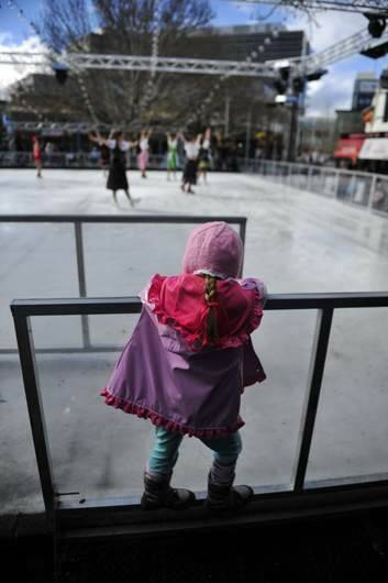 A young member of the crowd watches the ACT Ice Skaters perform at the ice skating rink at Civic on Saturday. Photo: Jay Cronan
