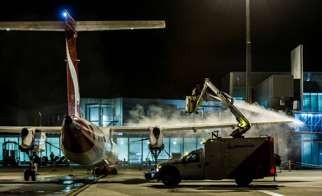 De-iceing work on the Qantas aircraft at Canberra airport in sub-zero temperatures.  Photo: Karleen Minney