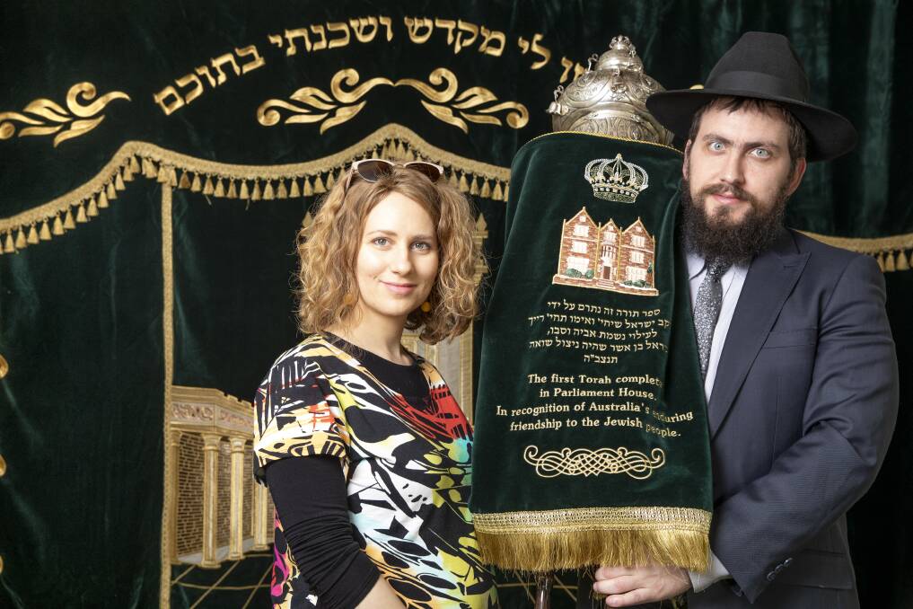 Rebbetzin Chasia Feldman and Rabbi Shmueli Feldman with the Torah at Chabad ACT.  Photo: Sitthixay Ditthavong