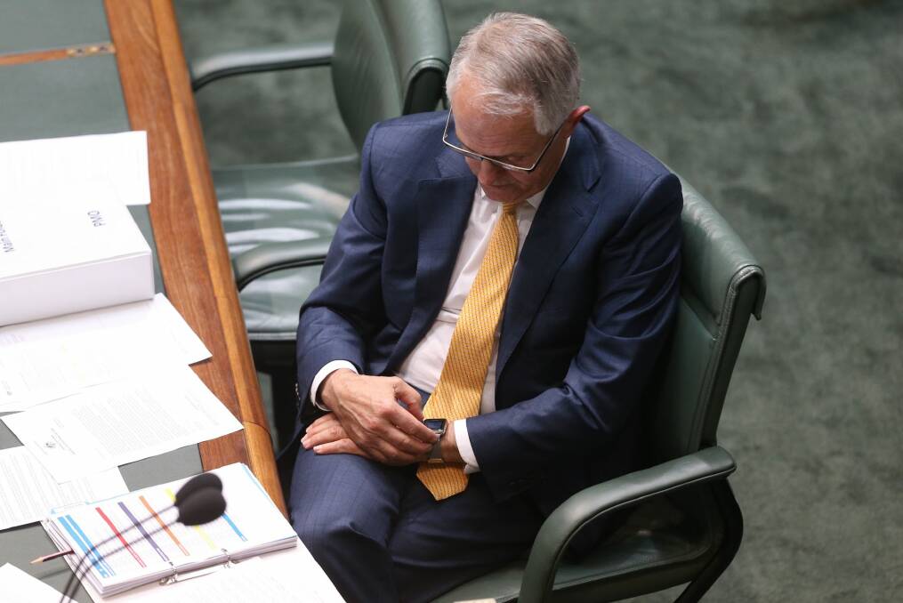 Prime Minister Malcolm Turnbull checks his Apple watch during question time. Photo: Andrew Meares