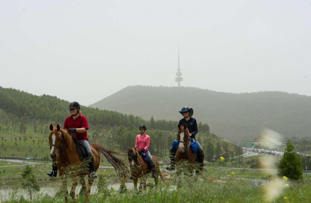Horse riders Belinda Cox, Angela Chapman and Paula Stagg at the National Arboretum as dust covers the sky over Canberra on Saturday morning. Photo: Elesa Kurtz