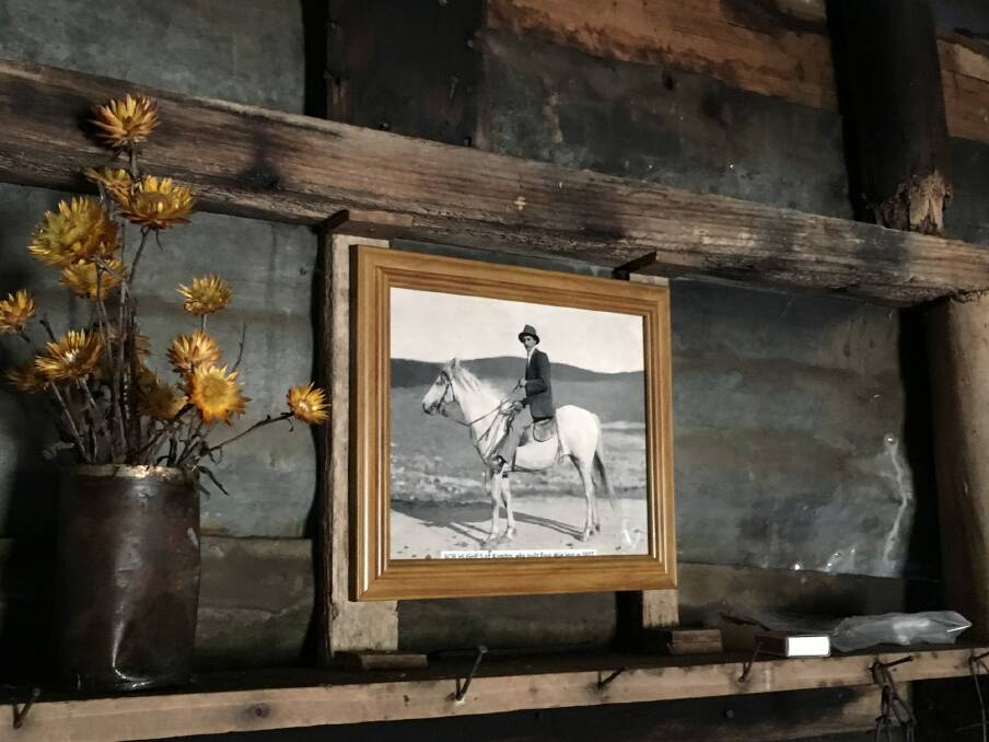 Photo of Bob Hughes and vase of everlasting daisies on the mantelpiece of Four Mile Hut. Photo: Tim the Yowie Man