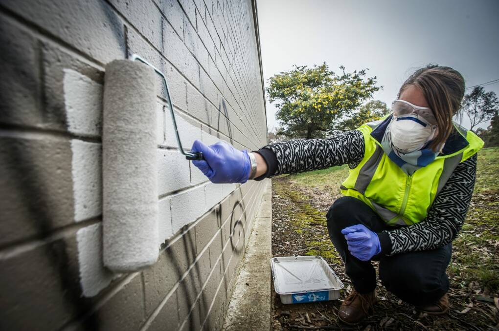 ACT Graffiti Management co-ordinator Louise Emberson removing some unwanted signage. Photo: Karleen Minney