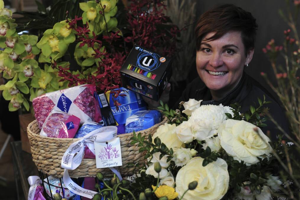 Moxom and Whitney florist on Lonsdale Street, Braddon. Co- owner, Belinda Whitney with a donation basket full of women's sanitary products, donated by customers for the Share the Dignity campaign. Photo: Graham Tidy
