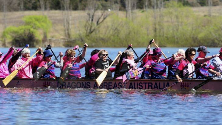 Paddlers prepare to perform the Flowers on the Water ceremony, observing a minute's silence in memory of women who have lost their battle with breast cancer. Photo: Graham Tidy