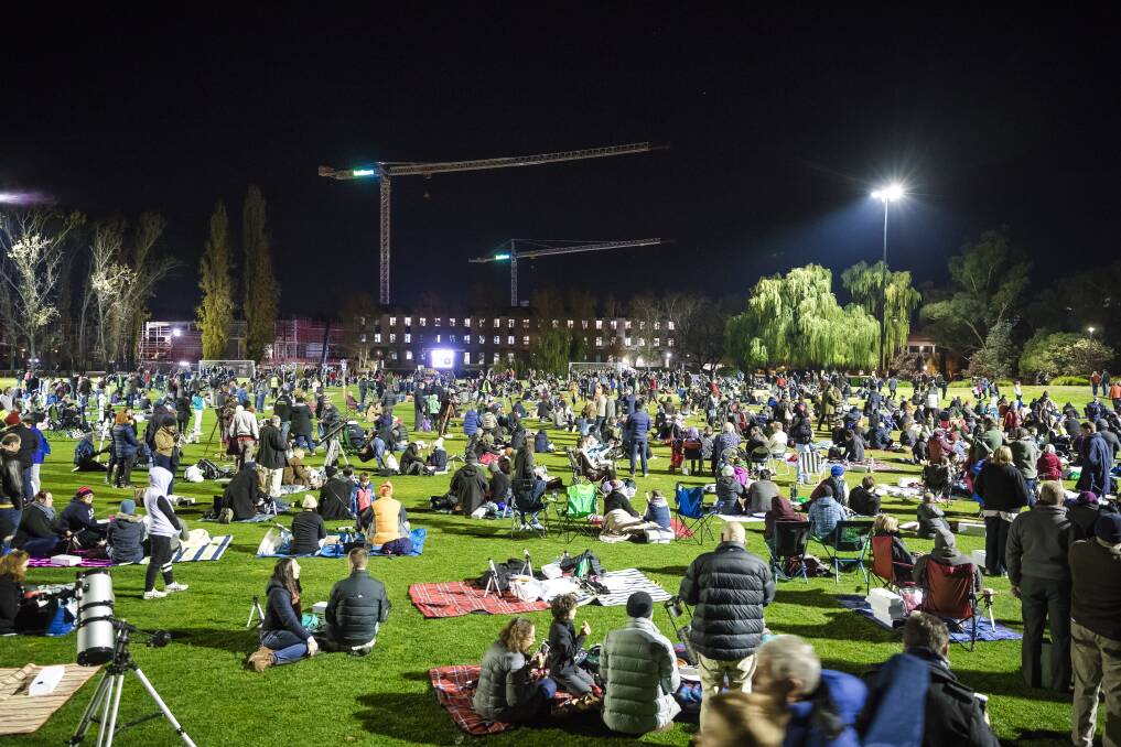 The crowd at the Australian National University's Fellows Oval begins to swell as more people arrive for an attempt to break the Guinness World Record for the most people simultaneously stargazing at multiple venues. Photo: Sitthixay Ditthavong