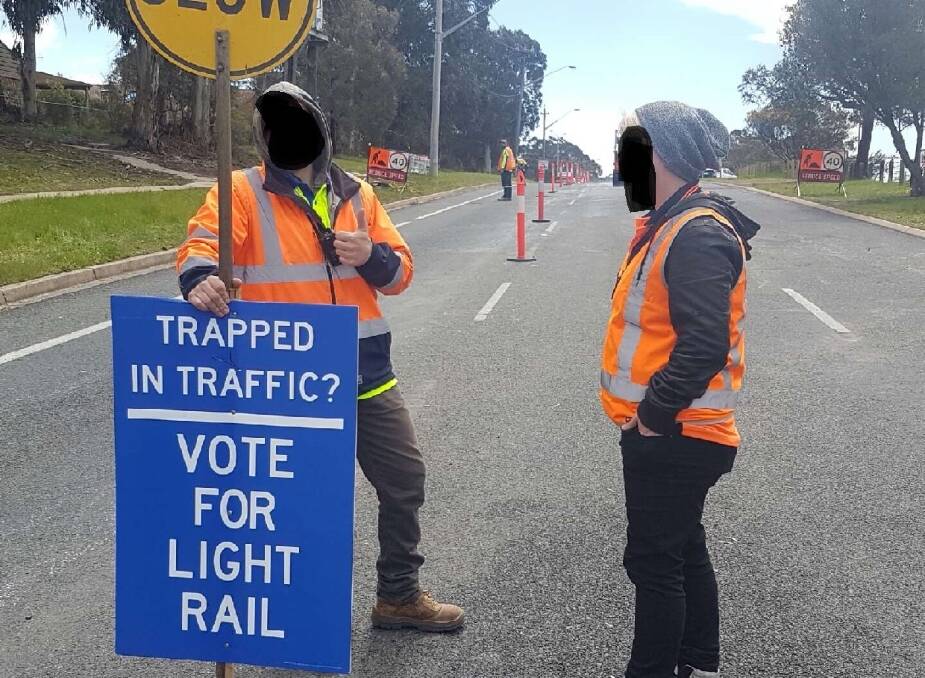 Road workers hold pro-light rail signs in Woden. Photo: supplied