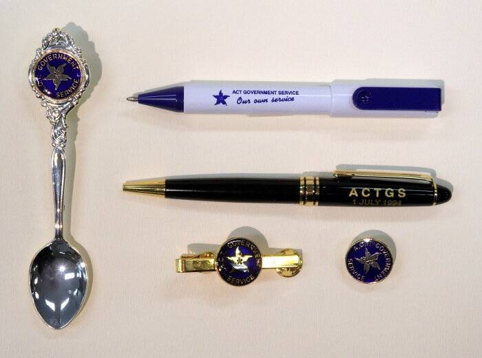 Souvenir spoon, pens, tie-clip and badge to commemorate the new ACT Government Service. Photo: Territory Records Office