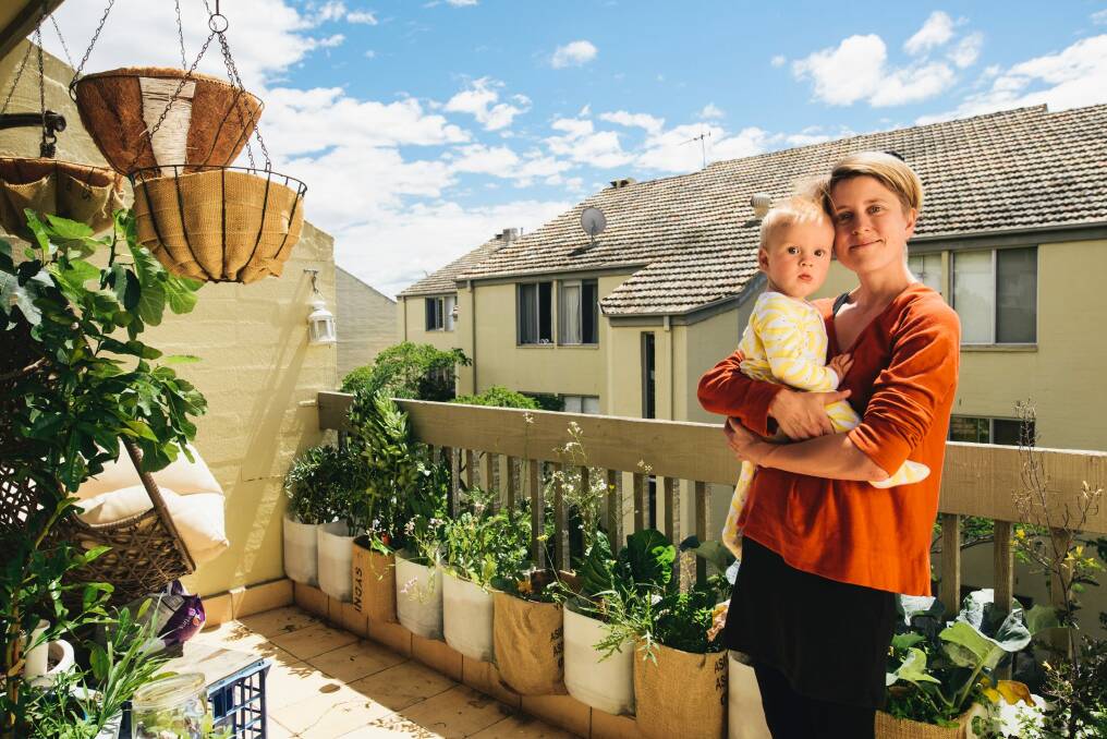 Alex Lamb with her son Louis. Alex is lobbying the body corporate to put solar panels on the roof. Photo: Rohan Thomson
