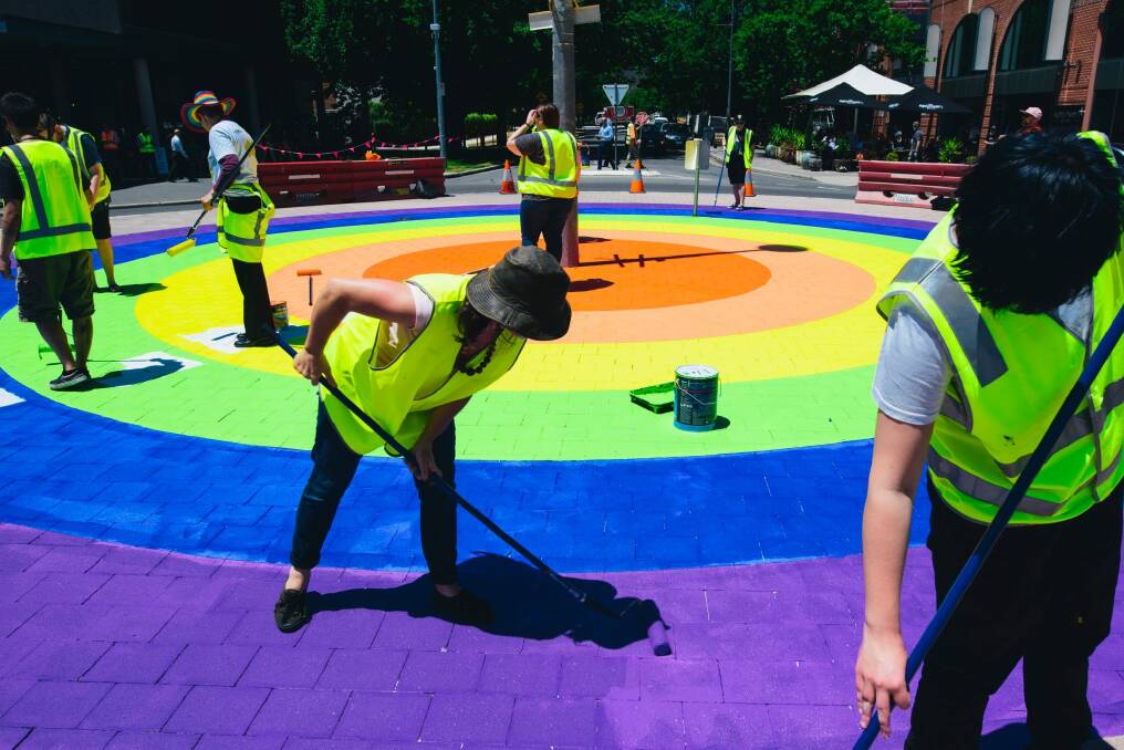 Members of the community paint the final touches on the rainbow roundabout on the corner of Elouera St and Lonsdale St in Braddon. Photo: Rohan Thomson