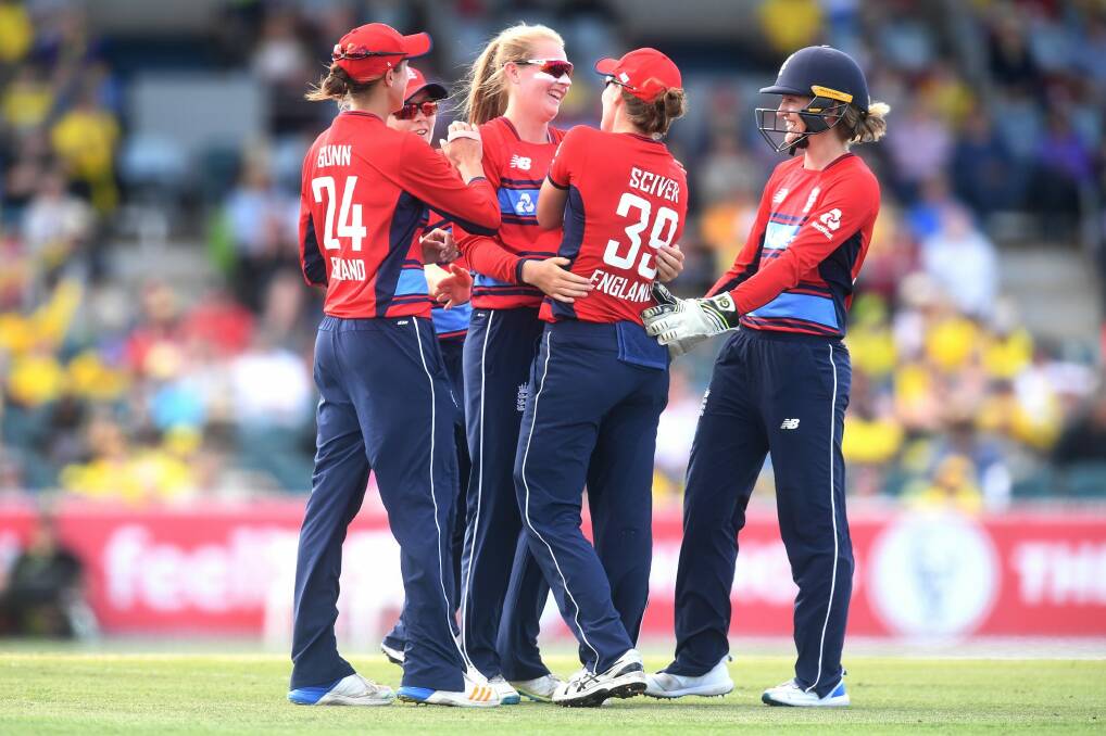 Sophie Ecclestone of England (centre) celebrates with teammates after claiming the wicket of Delissa Kimmince. Photo: AAP