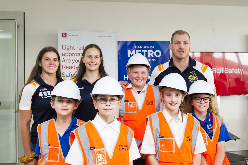 Brumbies players Darcy Read, Claudia Obst and David Pocock with students from Harrison School at the launch of the Tackle Rail Safety Campaign at the Light Rail Depot.  Photo: Dion Georgopoulos