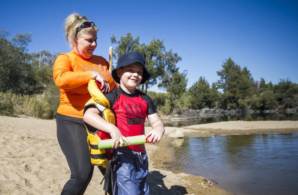 Royal Life Saving's project officer, Jackie Rouosseau, gives Ethan Wise, six, key swimming skills in wearing a life vest at Pine Island Reserve.  Photo: Elesa Kurtz