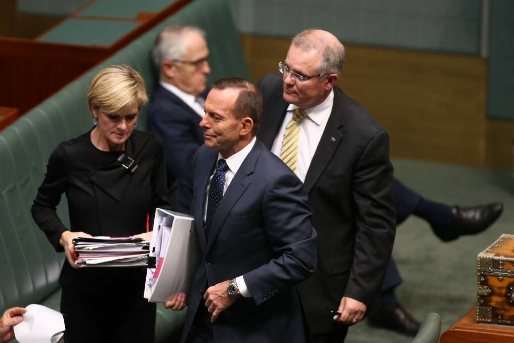 Prime Minister Tony Abbott departs question time with Julie Bishop and Scott Morrison while Malcolm Turnbull remains on the frontbench. Photo: Andrew Meares