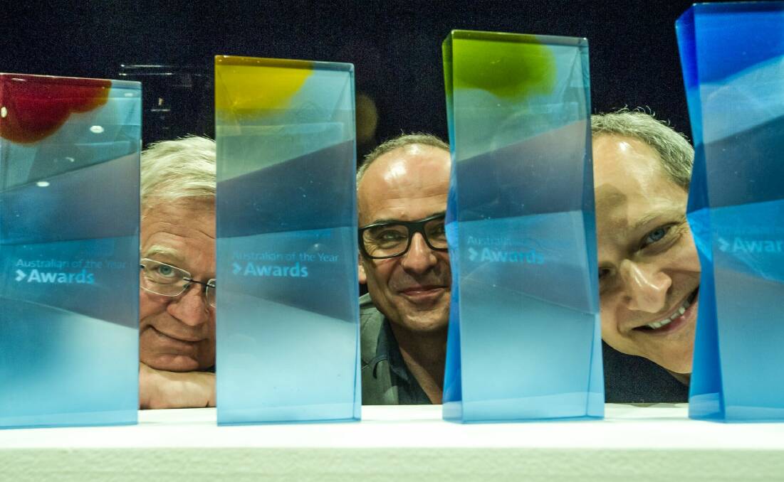 From left, ANU vice-chancellor  Brian Schmidt, head of glassworks Richard Whiteley, and head of music Kenneth Lampl reveal the ANU-designed glass trophies for the Australian of the Year Awards.  Photo: Karleen Minney