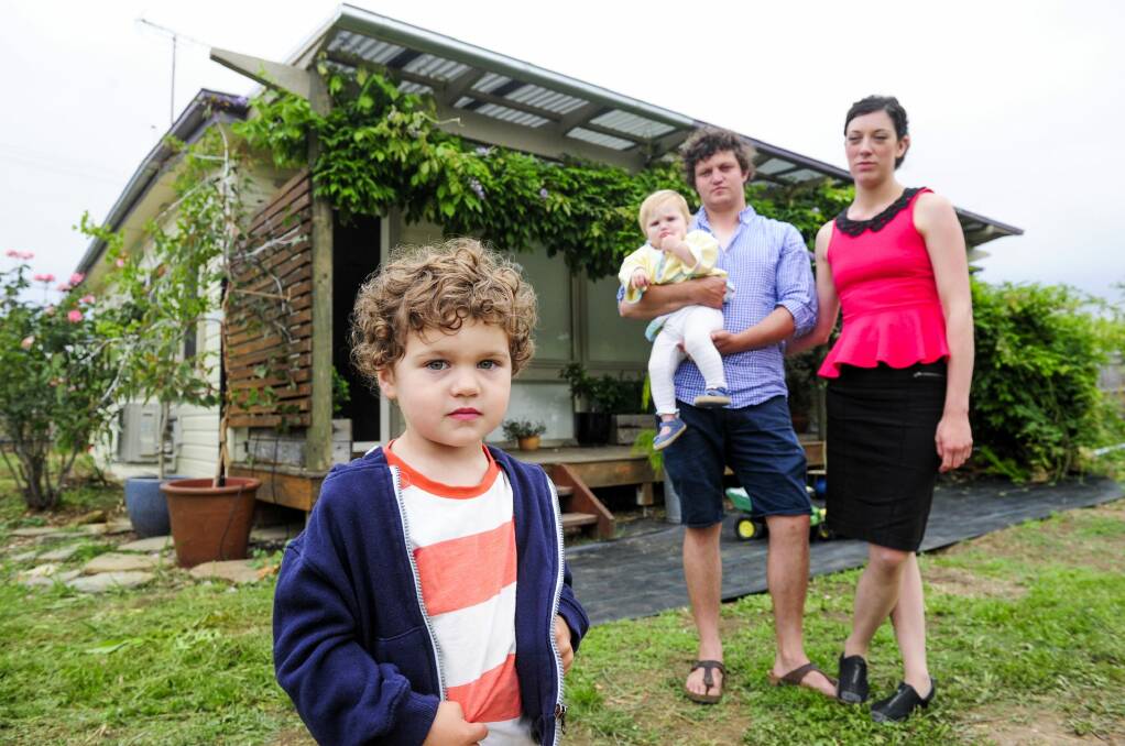 Eddie Casey and his partner Dale Freestone with their children Grace Casey, 1, and Leon Casey, 3, outside their home in Bungendore which contains Mr Fluffy asbestos. Photo: Melissa Adams