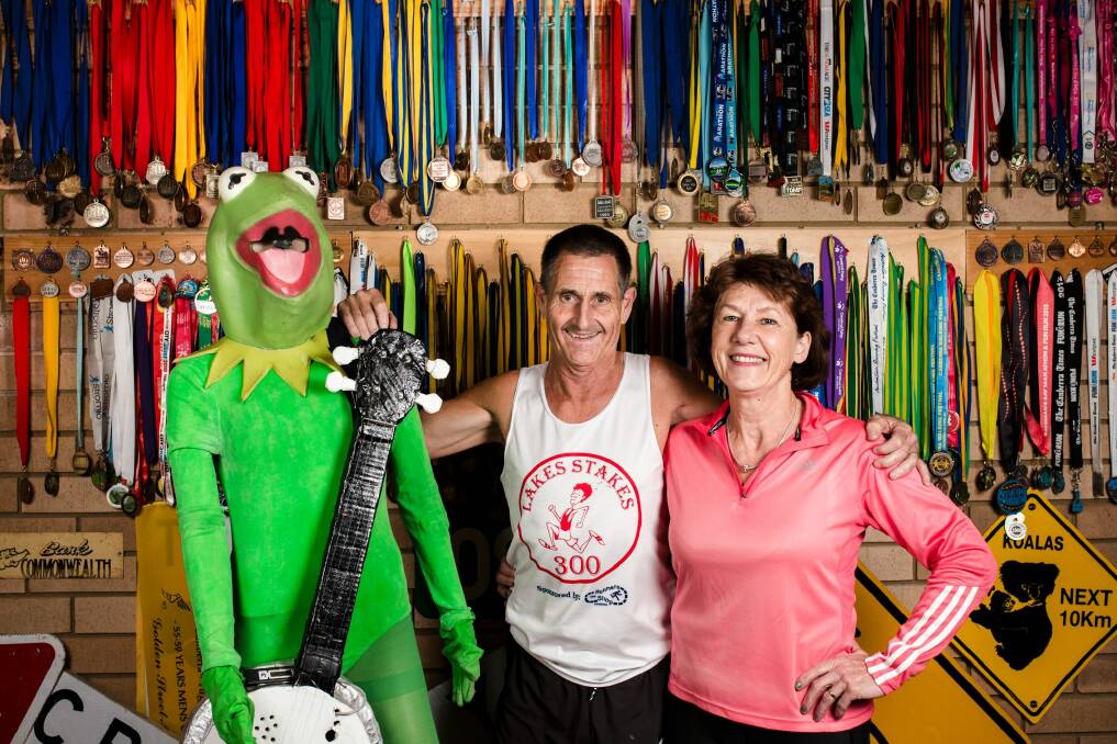 Maria and Jim White with their Canberra Times fun run medals, along with Jims kermit the frog fun run costume. Maria and Jim have been participating in the Canberra Times fun run for 40 years.  Photo: Jamila Toderas
