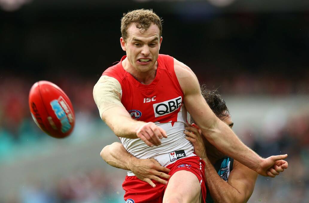 Big win: Tom Mitchell gets a kick away in the wet conditions. Photo: Getty Images