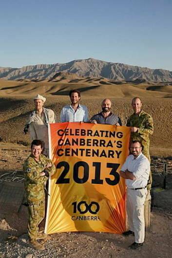 BANNER MOMENT: Unfurling the Canberra centenary flag, from left – back row, DFAT’s Fred Smith, AusAid’s Steve Burns and Brek Batley and Major Haydn Barlow;  Front, Corporal Chris Moore and DFAT’s David Windsor. Photo: Supplied
