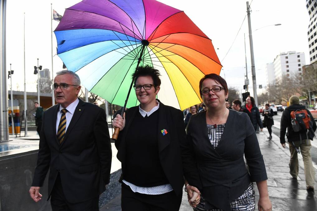 Mother-of-three Felicity Marlowe (centre) and her partner Sarah Marlowe with MP Andre Wilkie after appearing for a High Court injunction hearing application against the voluntary same-sex marriage postal survey. Photo: AAP