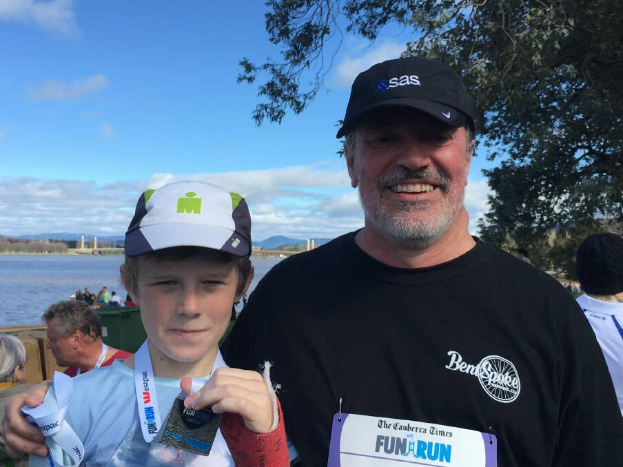 Liam, 11, and father Paul Tainsh, at the end of the 14km Canberra Times fun run on Sunday. Photo: Kirsten Lawson